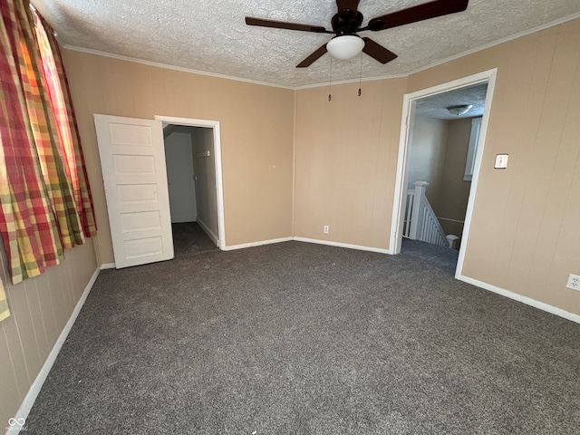 unfurnished bedroom with dark carpet, a textured ceiling, and ceiling fan