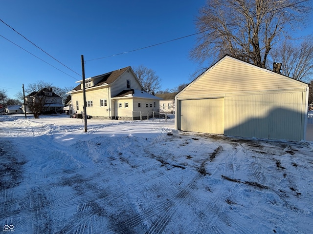 view of snow covered exterior with a garage and an outdoor structure