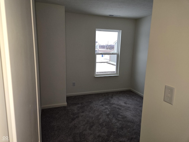 carpeted empty room with a textured ceiling