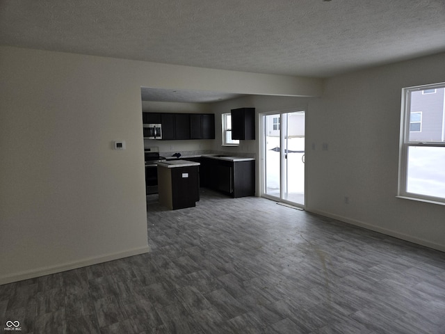 kitchen featuring a textured ceiling, a kitchen island, and stainless steel appliances