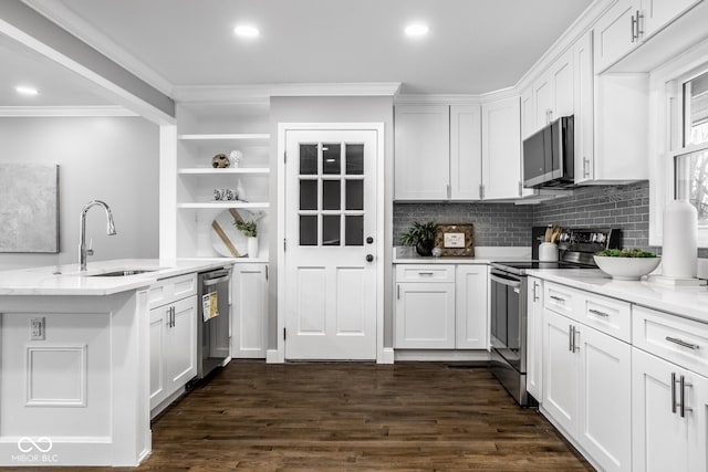 kitchen with stainless steel appliances, white cabinetry, sink, and light stone counters