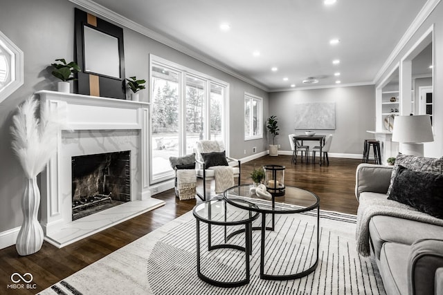 living room with crown molding, dark wood-type flooring, a high end fireplace, and built in features