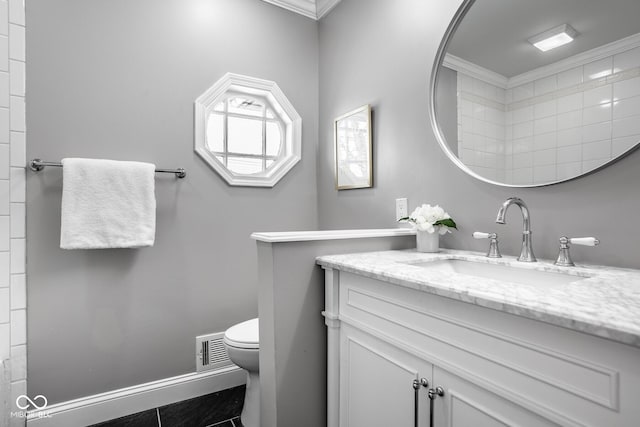 bathroom featuring tile patterned flooring, vanity, ornamental molding, and toilet