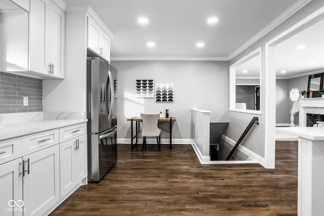 kitchen featuring white cabinetry, tasteful backsplash, stainless steel refrigerator, dark hardwood / wood-style floors, and light stone countertops