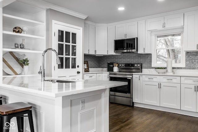 kitchen featuring stainless steel appliances, light stone countertops, sink, and white cabinets