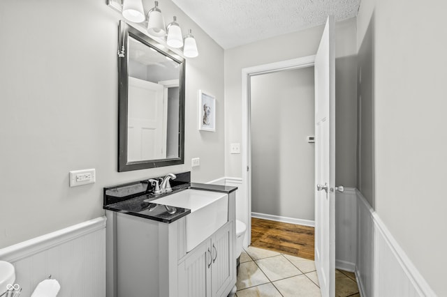 bathroom with vanity, tile patterned floors, a textured ceiling, and toilet