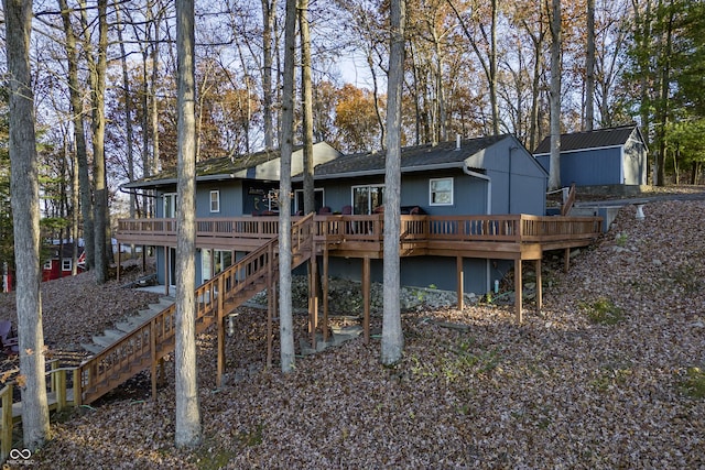 rear view of house with a storage shed and a wooden deck