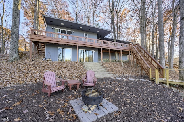 back of property featuring a deck and an outdoor fire pit