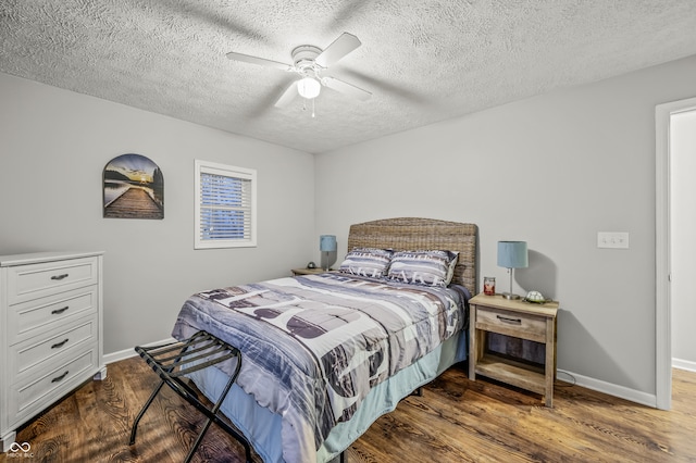 bedroom with ceiling fan, wood-type flooring, and a textured ceiling