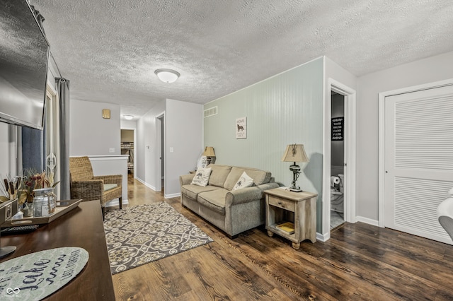 living room featuring dark hardwood / wood-style floors and a textured ceiling