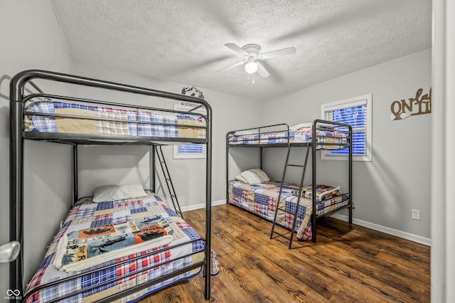 bedroom featuring ceiling fan, dark wood-type flooring, and a textured ceiling