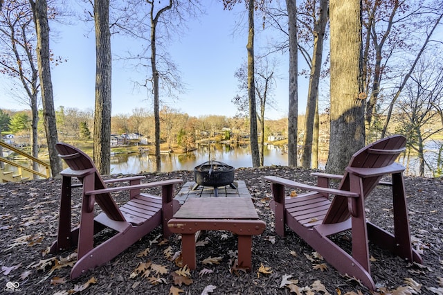 exterior space featuring a water view and an outdoor fire pit