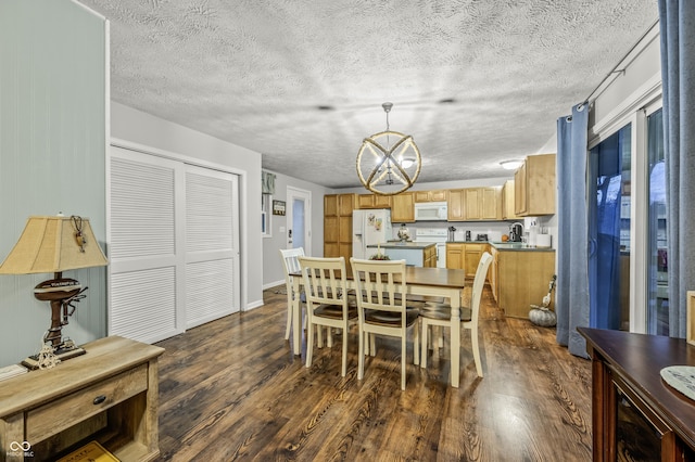 dining room featuring sink, dark hardwood / wood-style flooring, and an inviting chandelier