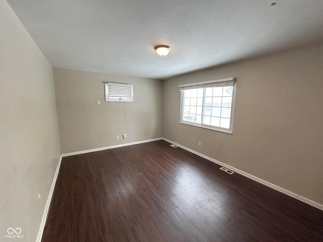 spare room with dark hardwood / wood-style flooring