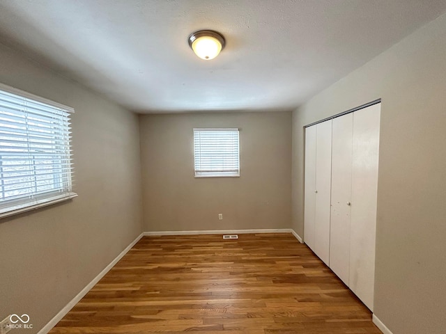 unfurnished bedroom with wood-type flooring and a closet