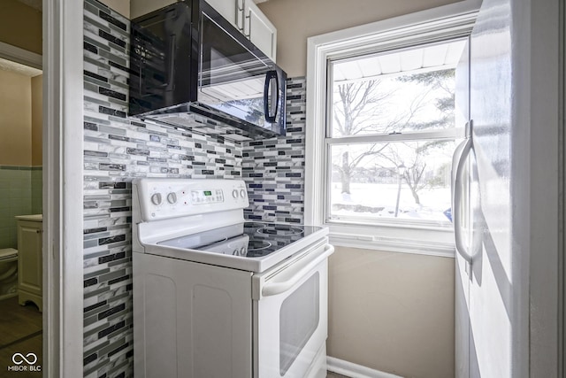 kitchen with white cabinets, backsplash, and white appliances