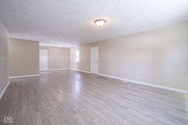 empty room with hardwood / wood-style floors and a textured ceiling