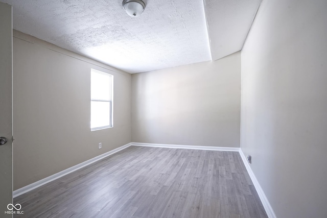 spare room featuring a textured ceiling and hardwood / wood-style flooring