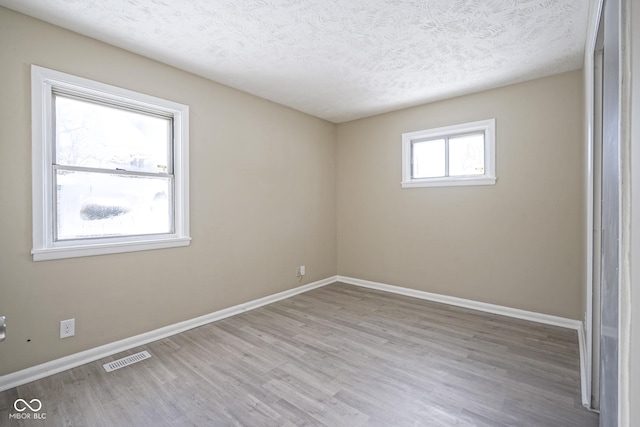 empty room featuring light hardwood / wood-style floors and a textured ceiling