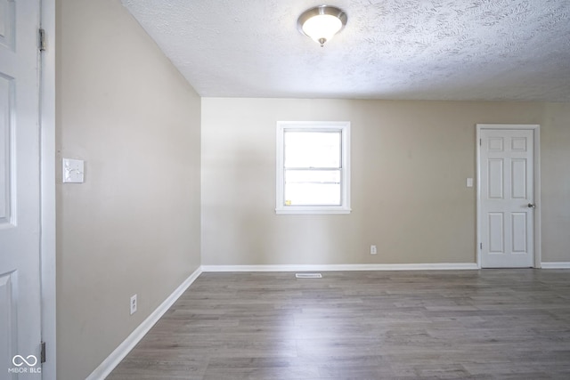 empty room featuring hardwood / wood-style flooring and a textured ceiling