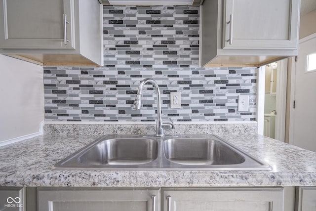 kitchen featuring gray cabinets, backsplash, and sink