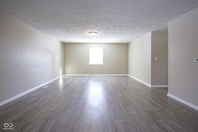 unfurnished room with a textured ceiling and dark hardwood / wood-style flooring