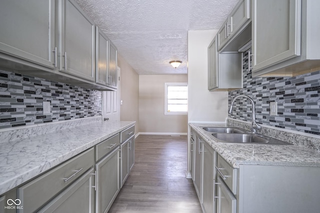 kitchen with backsplash, sink, and gray cabinetry