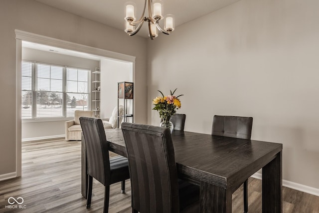 dining room with light wood-type flooring and a chandelier