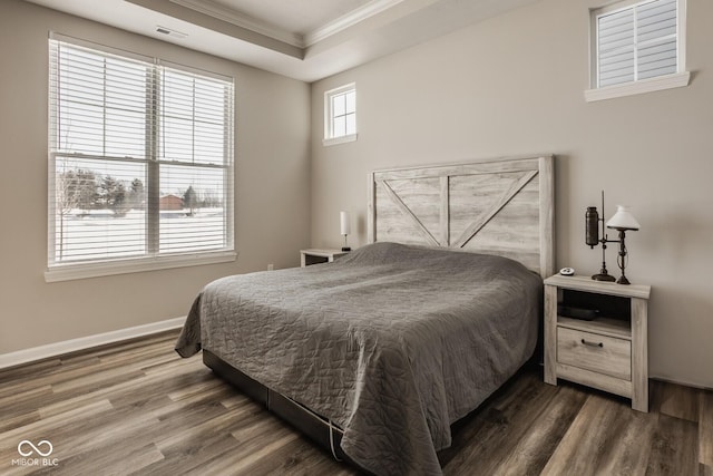 bedroom featuring a raised ceiling, crown molding, and dark hardwood / wood-style floors