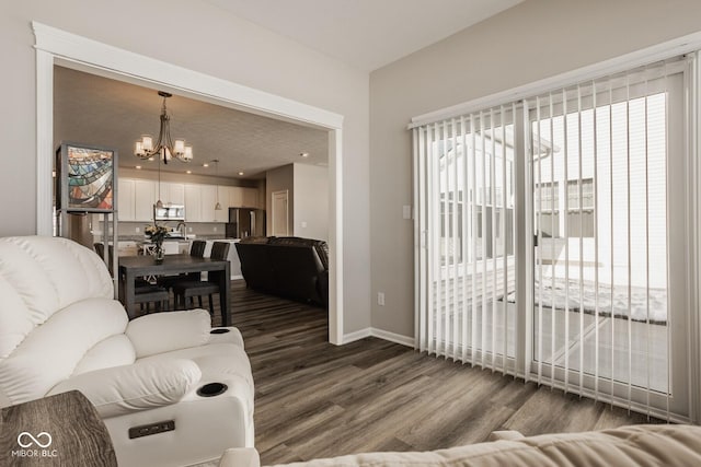 living room with a notable chandelier, hardwood / wood-style floors, and plenty of natural light