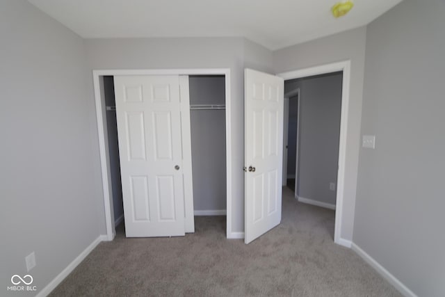 unfurnished bedroom with carpet flooring, baseboards, and a closet