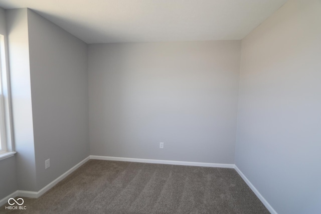 empty room with baseboards and carpet