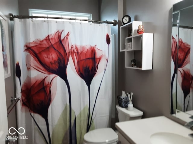 bathroom with toilet, walk in shower, and vanity