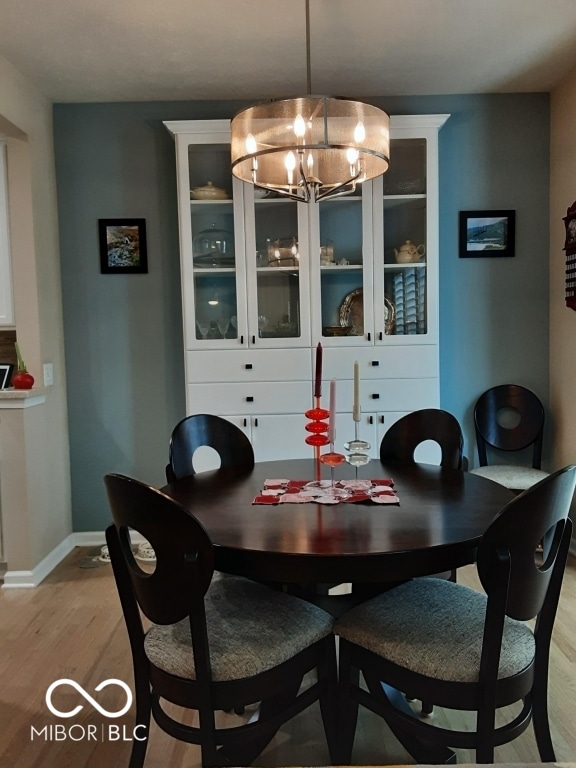 dining space with a notable chandelier and light hardwood / wood-style floors