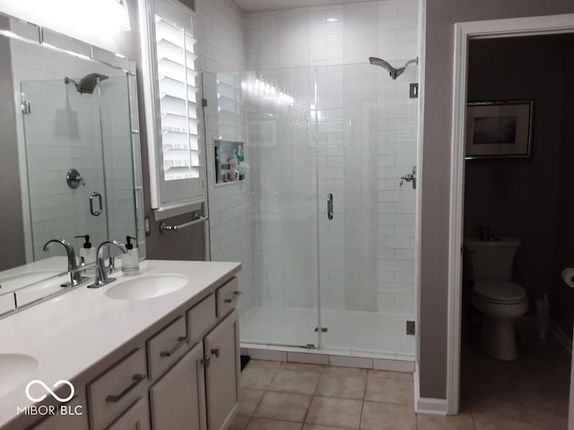 bathroom with vanity, a shower with shower door, tile patterned floors, and toilet