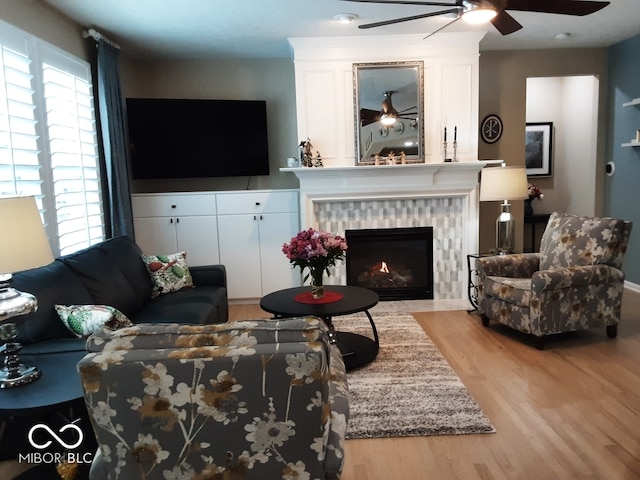 living room featuring a tile fireplace and light hardwood / wood-style flooring