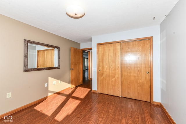 unfurnished bedroom featuring a closet and dark hardwood / wood-style flooring