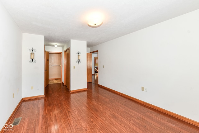 empty room featuring a textured ceiling and hardwood / wood-style flooring