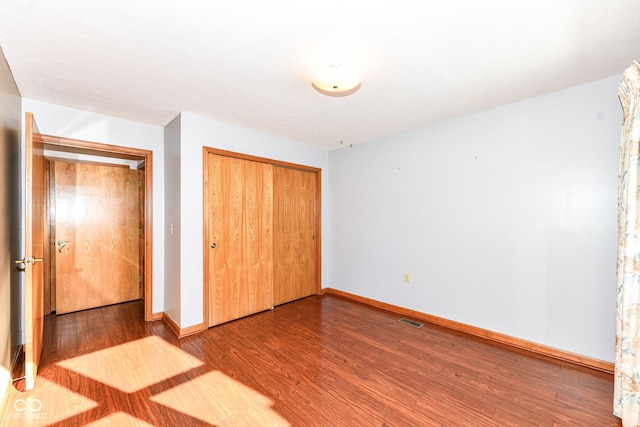 unfurnished bedroom featuring hardwood / wood-style floors and a closet