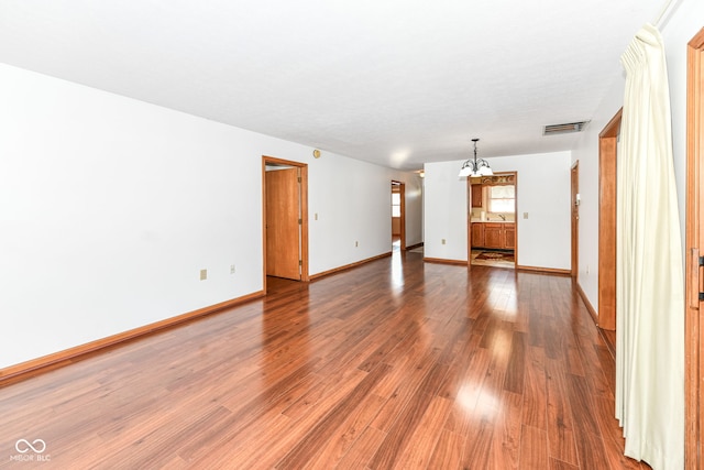 unfurnished room with hardwood / wood-style flooring and a chandelier