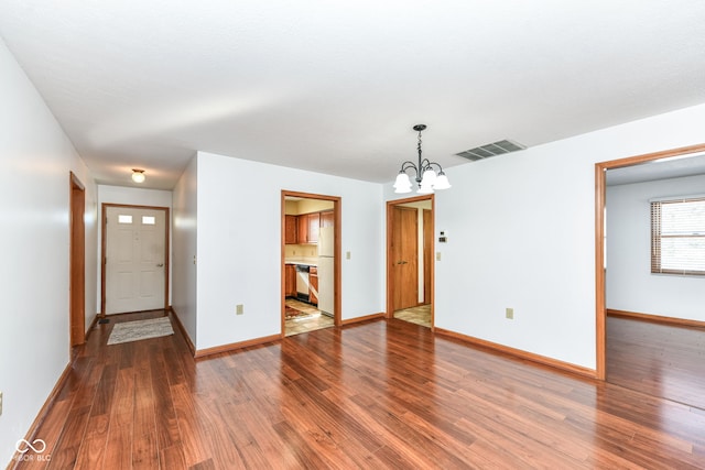 unfurnished living room featuring hardwood / wood-style floors and a notable chandelier