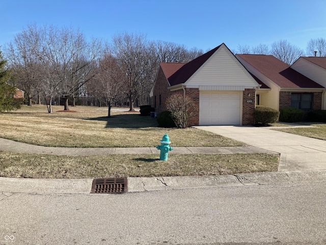 view of home's exterior with a yard, brick siding, concrete driveway, and an attached garage