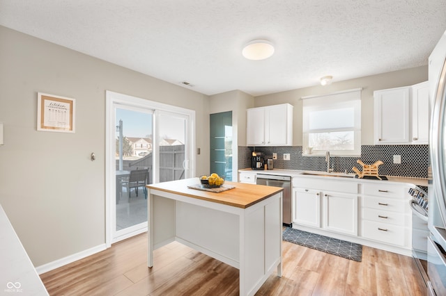 kitchen with a kitchen island, sink, white cabinetry, and appliances with stainless steel finishes