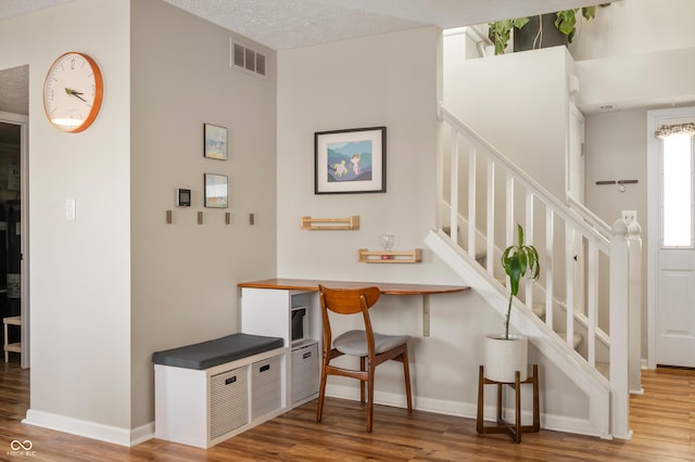 stairway featuring hardwood / wood-style floors and a textured ceiling