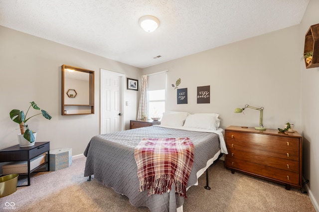 bedroom featuring light carpet and a textured ceiling