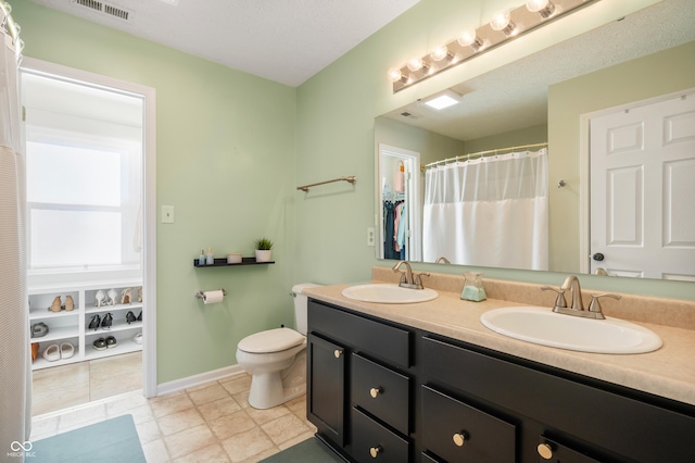 bathroom featuring vanity, toilet, and a textured ceiling