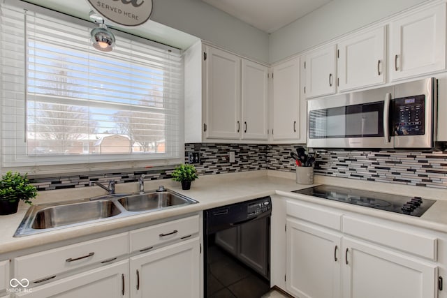 kitchen with decorative backsplash, sink, white cabinetry, and black appliances