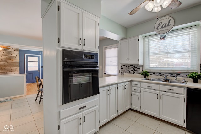 kitchen featuring white cabinetry, sink, backsplash, light tile patterned flooring, and black appliances