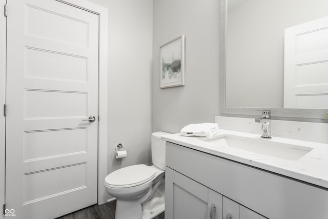 bathroom featuring vanity, wood-type flooring, and toilet