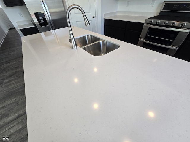 kitchen featuring appliances with stainless steel finishes, dark wood-type flooring, and sink